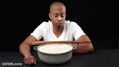 Man In White Shirt Holding Wooden Spoon Over Rice Bowl GIF