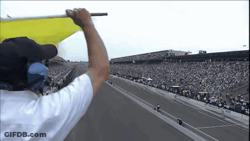 Man In White Shirt Holding Yellow Flag GIF