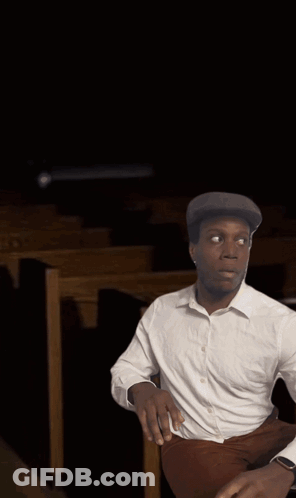 Man In White Shirt In Church With Altar Candles GIF