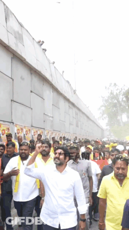 Man In White Shirt In Crowd Of Yellow Shirts GIF