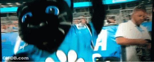 Man In White Shirt In Front Of Blue Sign Saying A GIF