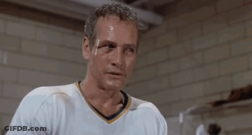 Man In White Shirt In Front Of Brick Wall Saying Okay GIF