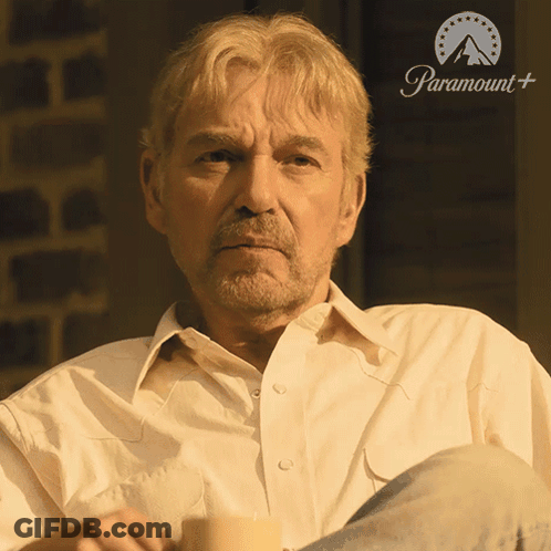 Man In White Shirt In Front Of Paramount Sign GIF