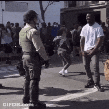 Man In White Shirt In Front Of Police Officer GIF