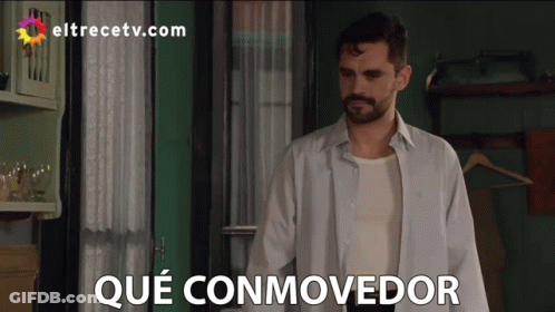 Man In White Shirt In Front Of Que Conmovedor Sign GIF