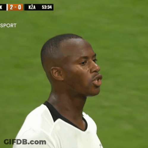 Man In White Shirt In Front Of Scoreboard Saying K 2-0 Kza GIF