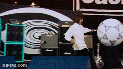 Man In White Shirt Kicking Soccer Ball In Front Of Clash Sign GIF