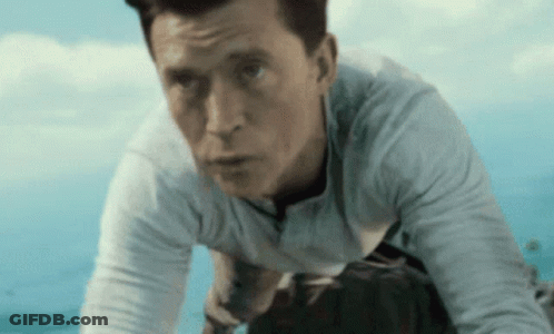 Man In White Shirt Kneeling Under Blue Sky GIF