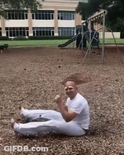 Man In White Shirt Laying On Ground In Park GIF