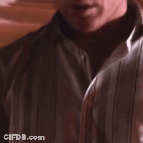 Man In White Shirt Looking At Camera GIF