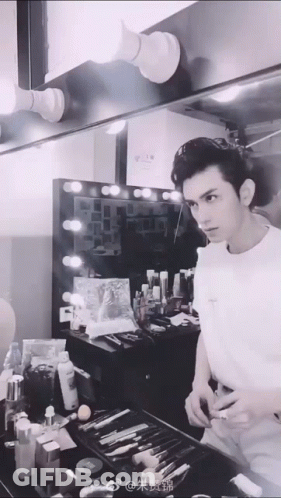 Man In White Shirt Looking At Mirror In Dressing Room GIF