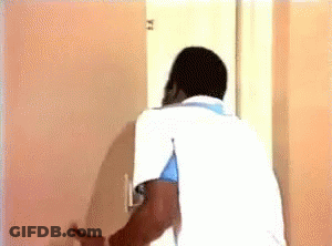 Man In White Shirt Looking Out Door GIF