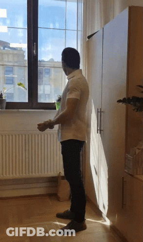 Man In White Shirt Looking Out Window GIF