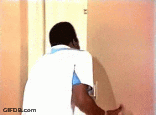Man In White Shirt Looking Through Door GIF