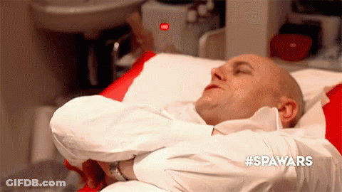 Man In White Shirt Lying In Hospital Bed Arms Crossed GIF