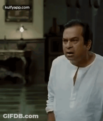 Man In White Shirt Making Funny Face In Living Room GIF