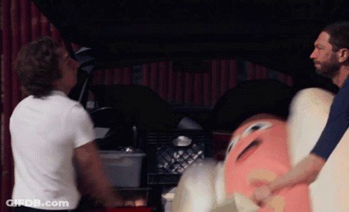 Man In White Shirt Next To Man In Blue Shirt Holding Stuffed Animal GIF