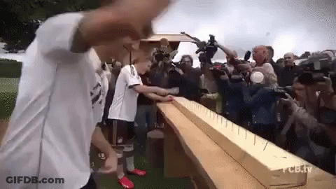Man In White Shirt Next To Wooden Plank With Nails GIF