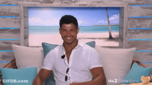 Man In White Shirt On Couch With Beach Picture GIF