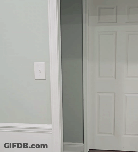 Man In White Shirt Peeking Out Of Doorway GIF