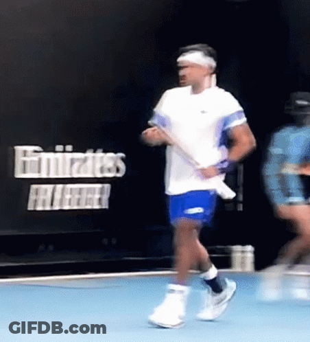 Man In White Shirt Playing Tennis In Front Of Emirates Sign GIF
