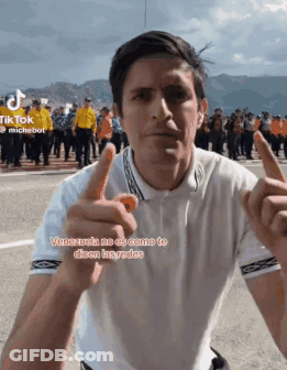 Man In White Shirt Pointing At Camera With Crowd GIF