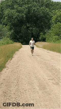 Man In White Shirt Running On Dirt Road GIF