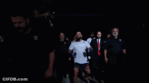 Man In White Shirt Running Through Crowd GIF