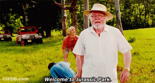 Man In White Shirt Saying Welcome To Jurassic Park GIF
