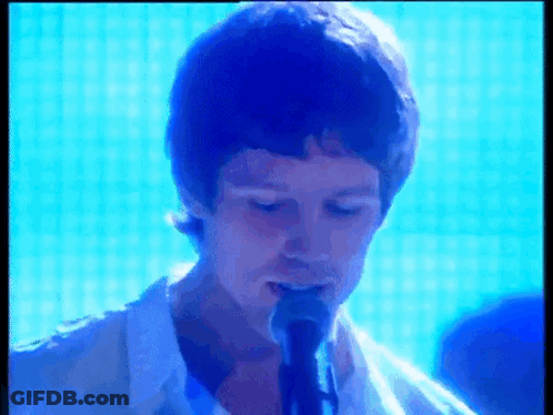 Man In White Shirt Singing Into Microphone GIF