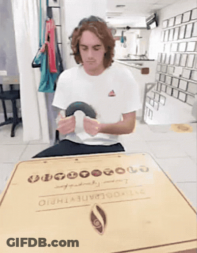 Man In White Shirt Sitting At Table With Box Saying 00000 GIF