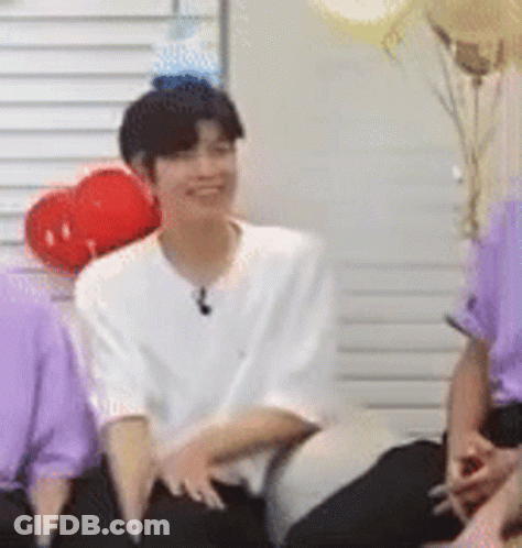 Man In White Shirt Sitting Next To Woman In Purple GIF