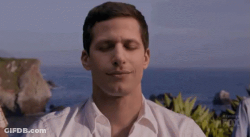 Man In White Shirt Sitting On Beach Eyes Closed Smiling GIF