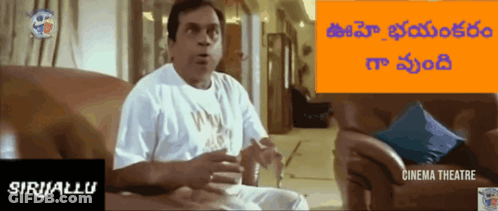 Man In White Shirt Sitting On Couch In Front Of Cinema Sign GIF