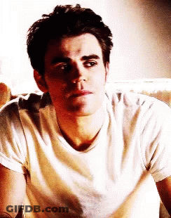 Man In White Shirt Sitting On Couch Looking At Camera GIF