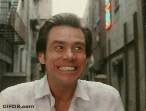 Man In White Shirt Smiling By Sign A In Alley GIF