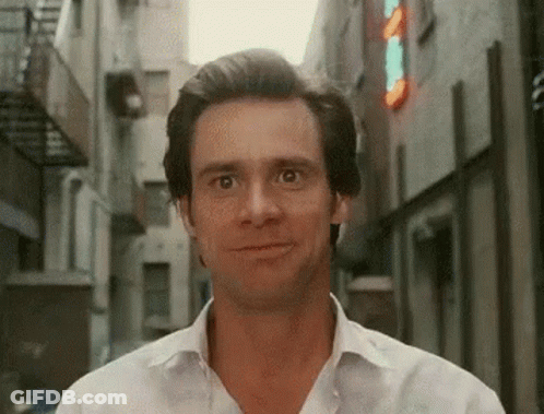 Man In White Shirt Smiling In Narrow Alleyway GIF