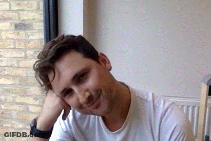 Man In White Shirt Smiling With Hand On Face GIF