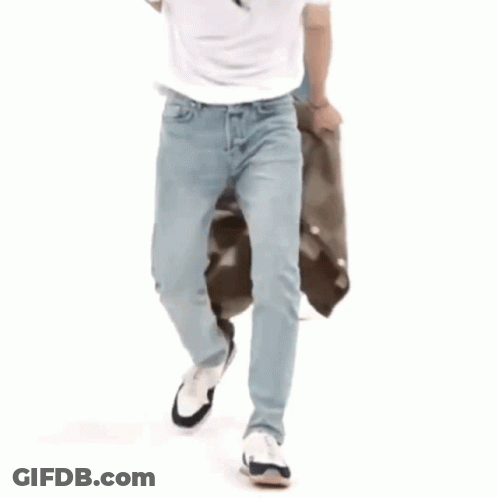 Man In White Shirt Squatting Next To Bag GIF