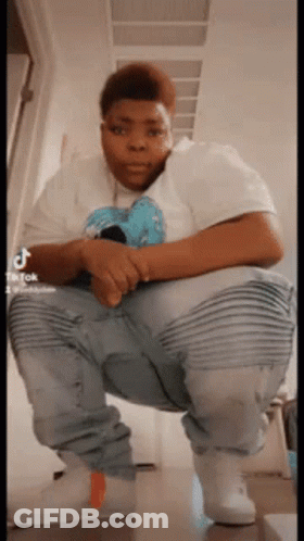 Man In White Shirt Squatting With Legs Crossed GIF
