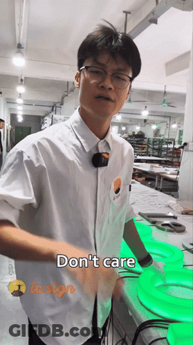 Man In White Shirt Standing Before Do Not Care Sign GIF