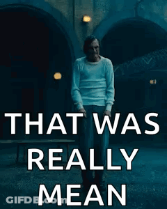 Man In White Shirt Standing Before Mean Sign GIF