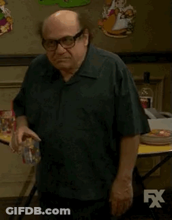 Man In White Shirt Standing By Couch And Star Wars Poster GIF