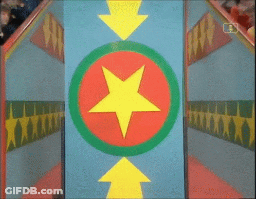 Man In White Shirt Standing In Colorful Room With NBC Sign GIF