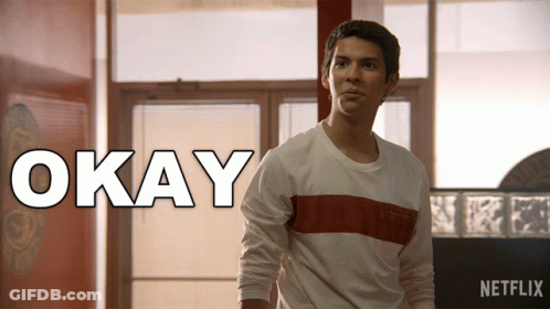 Man In White Shirt Standing In Front Of Okay Sign GIF