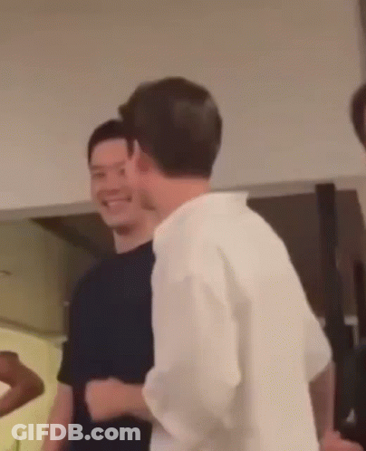 Man In White Shirt Standing Next To Man In Black Shirt GIF