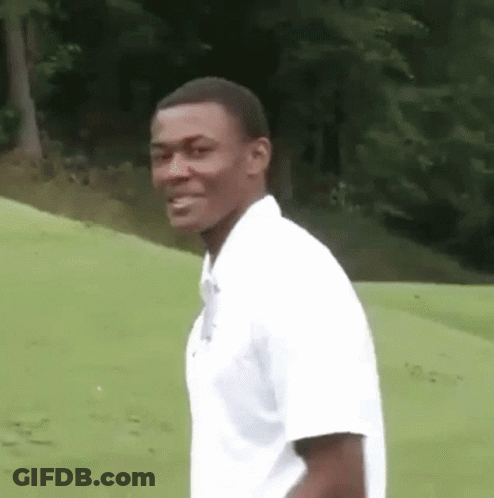 Man In White Shirt Standing On Green Field GIF