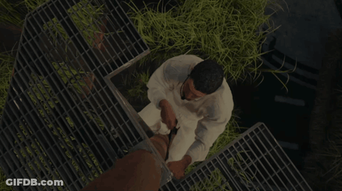 Man In White Shirt Standing On Metal Grid GIF