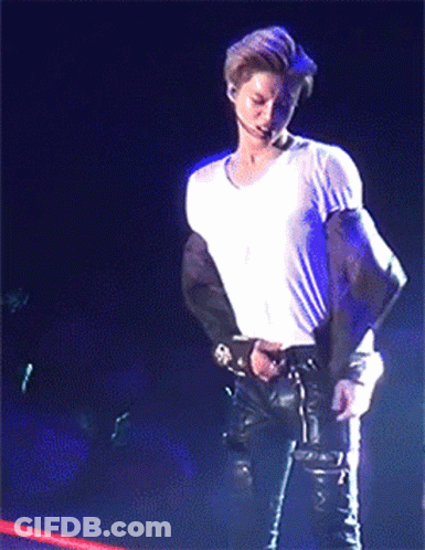 Man In White Shirt Standing On Stage Holding Microphone GIF
