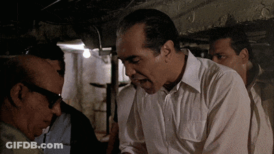 Man In White Shirt Talking To Another In Dark Room GIF